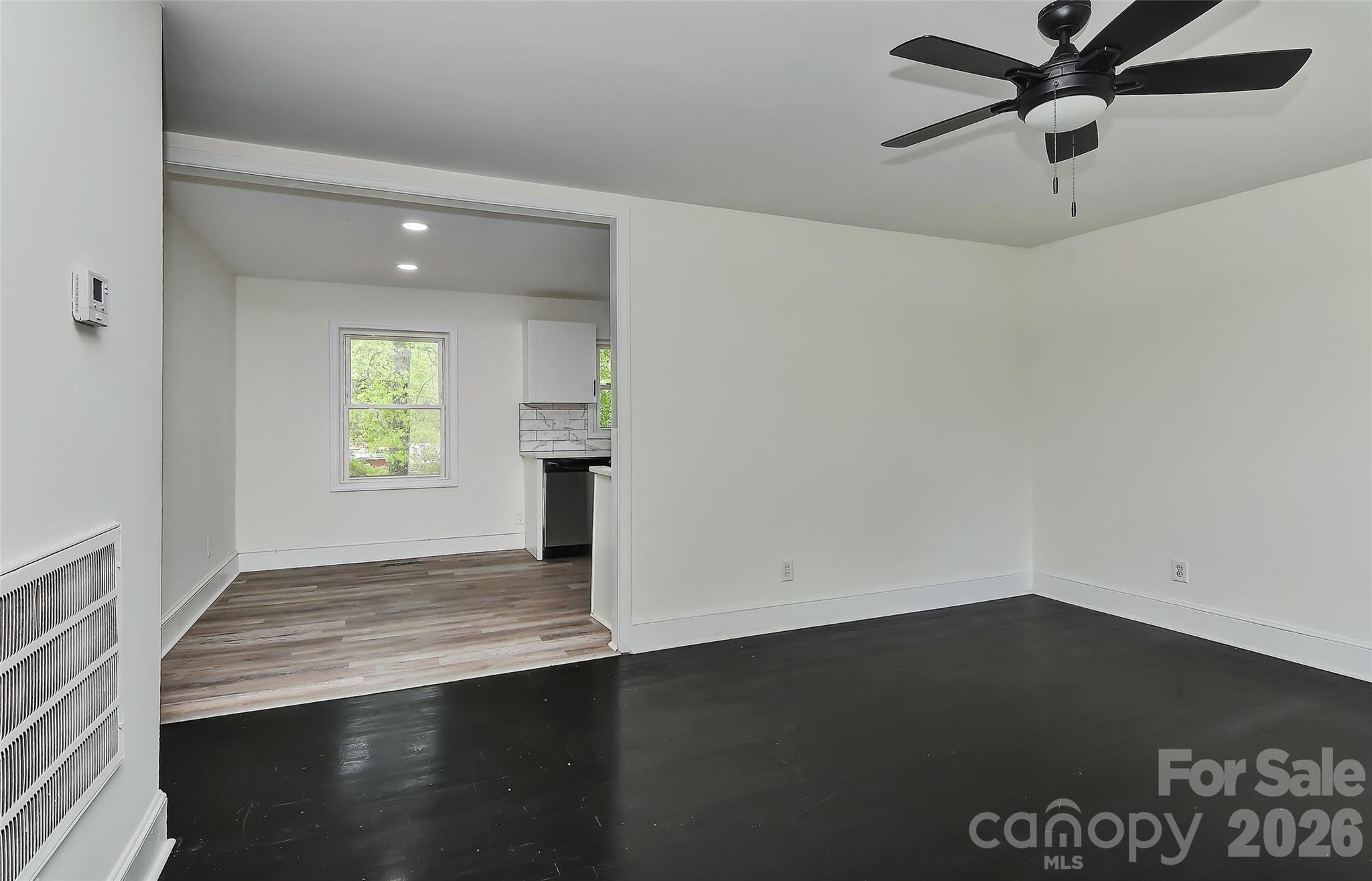 961 Clanton Road Charlotte, NC 28217 - Photo 7 of 23 an empty room with wooden floor cabinet and windows