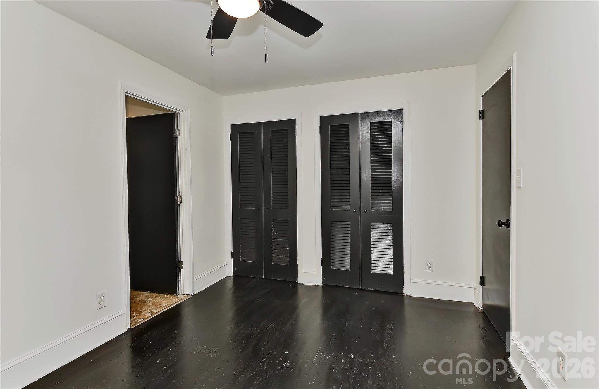961 Clanton Road Charlotte, NC 28217 - Photo 8 of 23 an empty room with wooden floor closet and windows