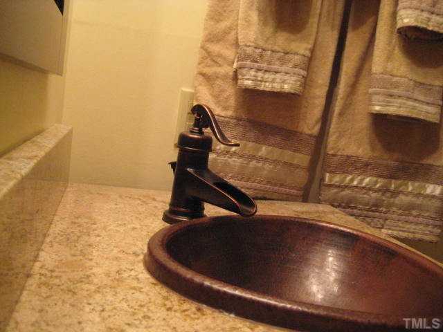 6904 Brecken Ridge Avenue Raleigh, NC 27615 - Photo 13 of 25 Yes, that is a granite countertop with designer fixtures and hammered copper sink. Who know washing your hands could be so much fun?