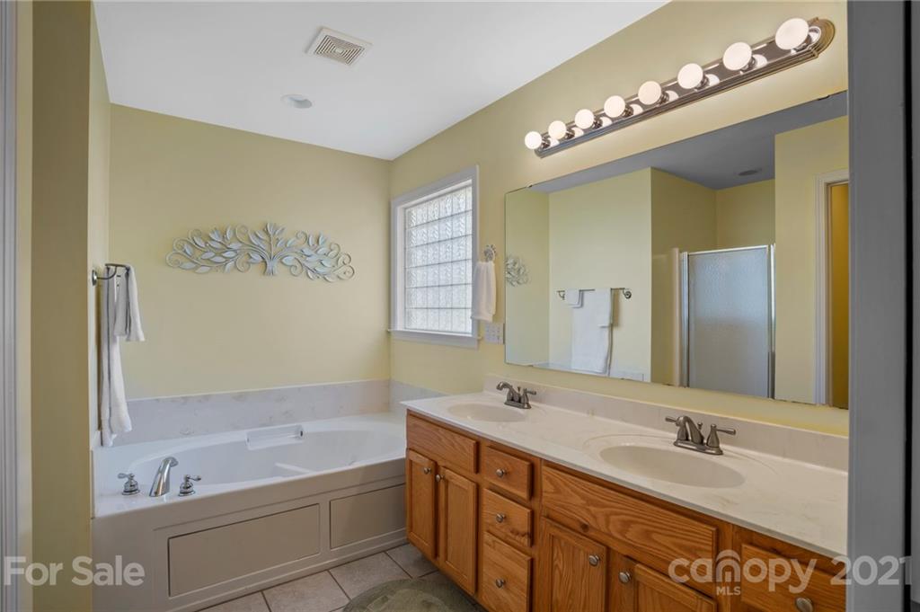 638 Maple Ridge Circle Salisbury, NC 28147 - Photo 31 of 48 a bathroom with a tub a double vanity sink and a mirror