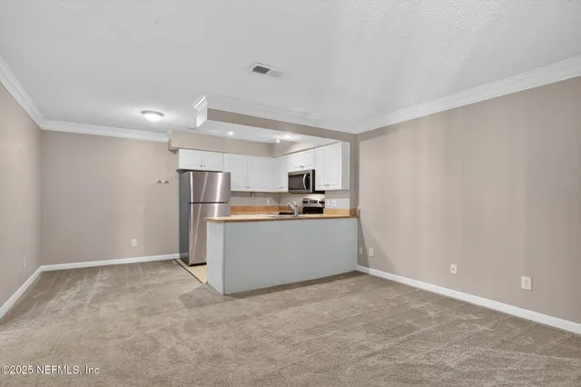 a view of kitchen with refrigerator cabinets and microwave