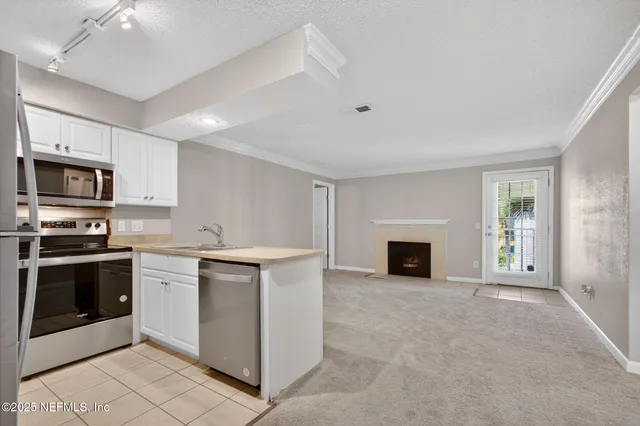 a view of a kitchen with a sink stove and cabinets