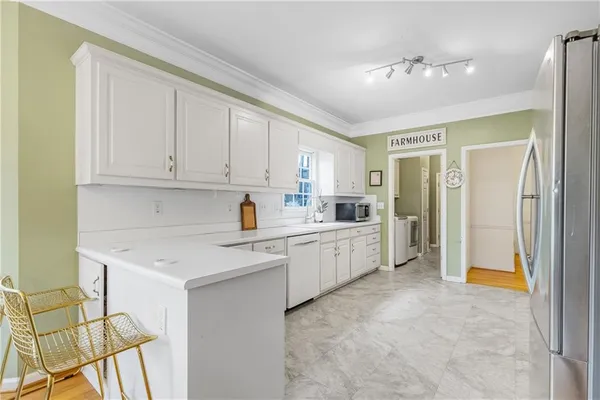 a large white kitchen with cabinets