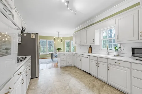 a kitchen with stainless steel appliances white cabinets and a refrigerator