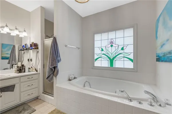 a spacious bathroom with a tub sink and mirror