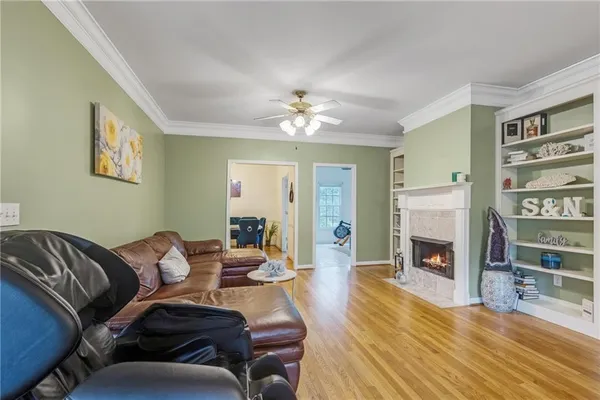 a dining room with wooden floor a chandelier a wooden table and chairs