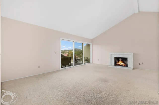 an empty room with a fireplace and large window