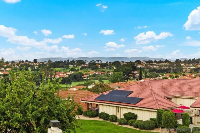 a view of residential houses with yard and ocean view