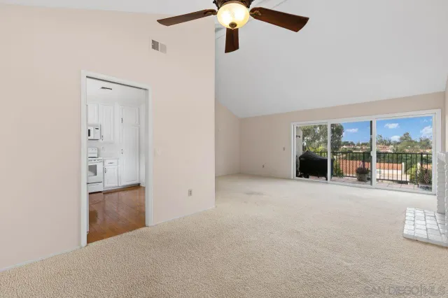 a view of an empty room with a fireplace and a window