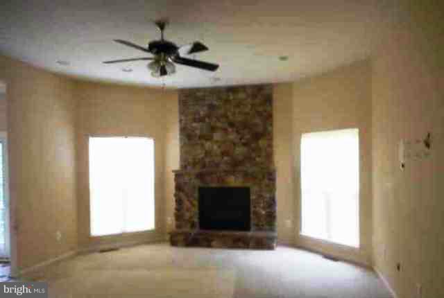 9906 Farm Pond Road Laurel, MD 20708 - Photo 7 of 11 a living room with a fireplace and a ceiling fan