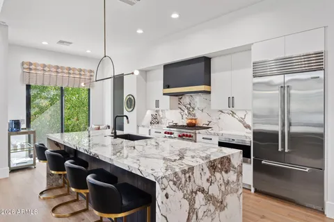 a kitchen with granite countertop a sink appliances a dining table and chairs