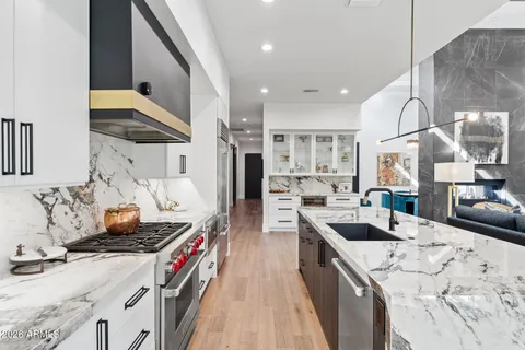 a kitchen that has a lot of cabinets a sink and appliances in it