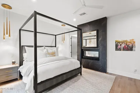 a bedroom with a large bed and a flat tv screen on dresser