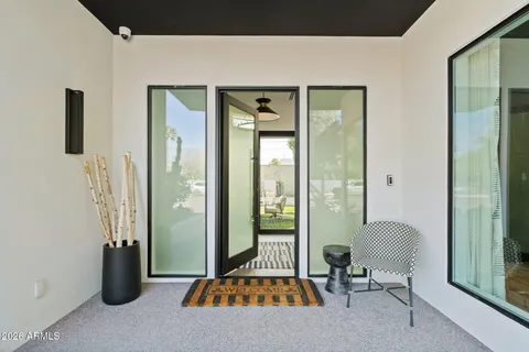 a living room with furniture a large window and a chandelier