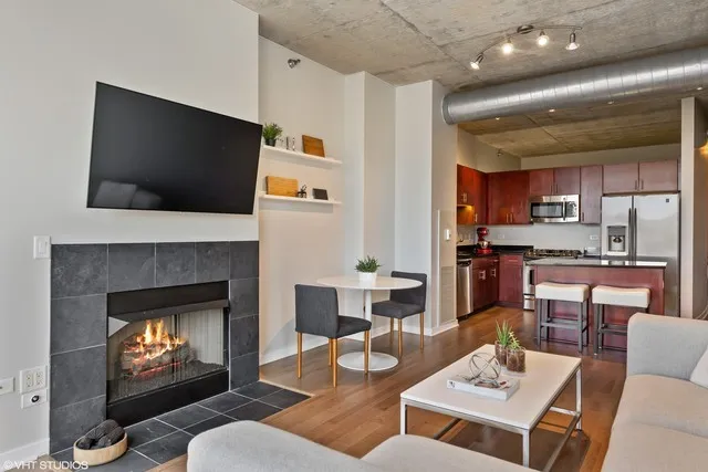 a living room with furniture a flat screen tv and a fireplace
