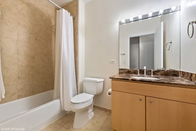 a bathroom with a granite countertop sink a toilet a mirror and shower