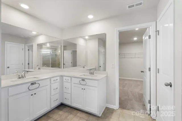 a spacious bathroom with a granite countertop sink mirror and double