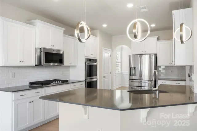 a kitchen with stainless steel appliances granite countertop a sink a stove and a granite counter tops
