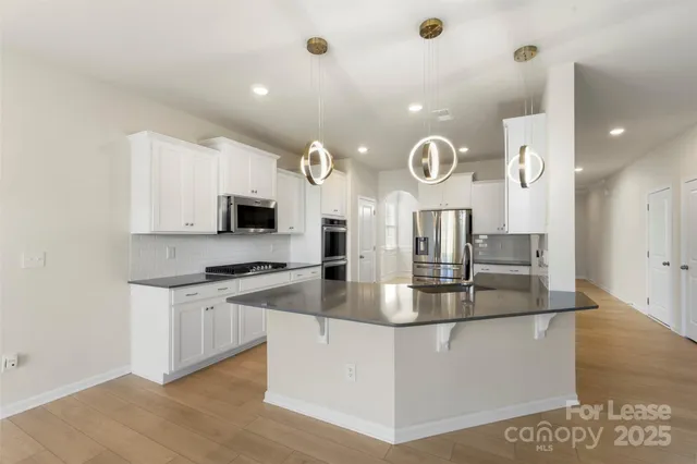 a kitchen with kitchen island granite countertop a stove and a sink