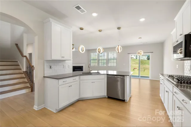 a large kitchen with stainless steel appliances granite countertop a stove and a sink