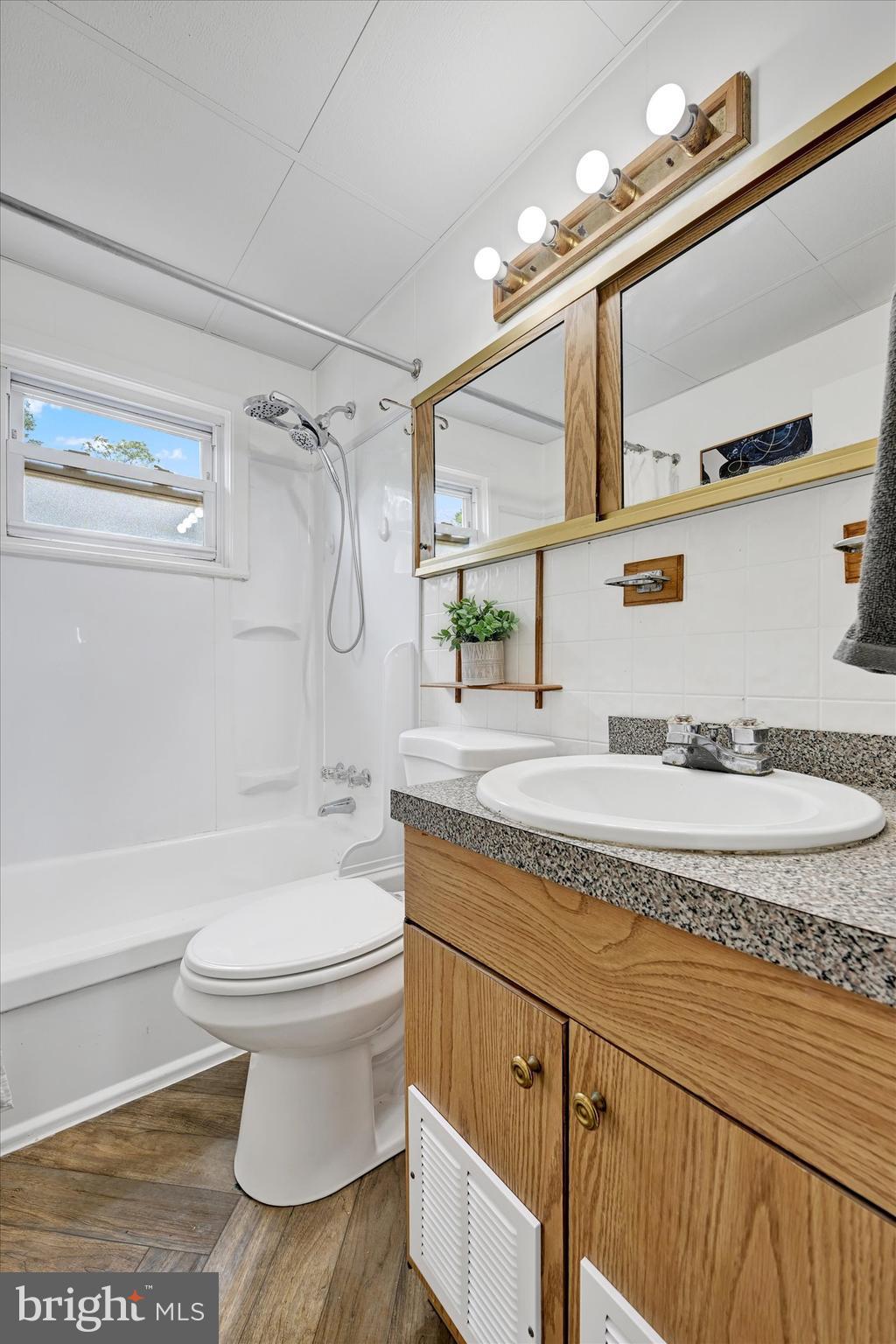 4428 Scotia Road Halethorpe, MD 21227 - Photo 18 of 28 a bathroom with a granite countertop sink toilet and a mirror