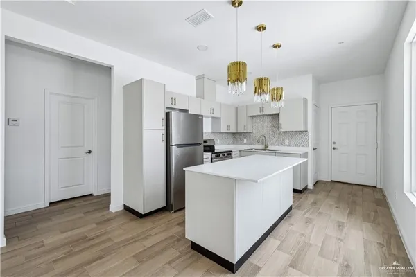 a view of kitchen with wooden floor and electronic appliances