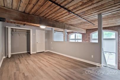 201 South Hoskins Road, Unit 111 Charlotte, NC 28208 - Photo 11 of 16 a view of an empty room with wooden floor and a window