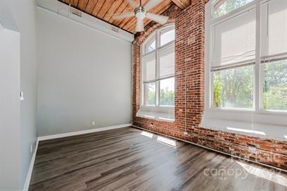 201 South Hoskins Road, Unit 111 Charlotte, NC 28208 - Photo 16 of 16 a view of an empty room with wooden floor and a window