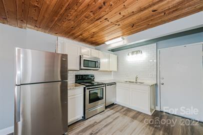 201 South Hoskins Road, Unit 111 Charlotte, NC 28208 - Photo 6 of 16 a kitchen with stainless steel appliances a refrigerator stove and sink