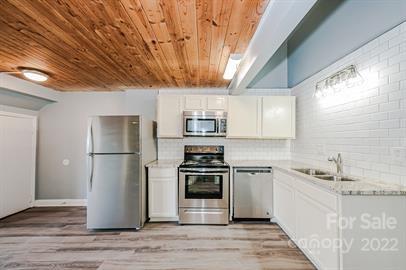 201 South Hoskins Road, Unit 111 Charlotte, NC 28208 - Photo 7 of 16 a kitchen with a refrigerator sink and cabinets