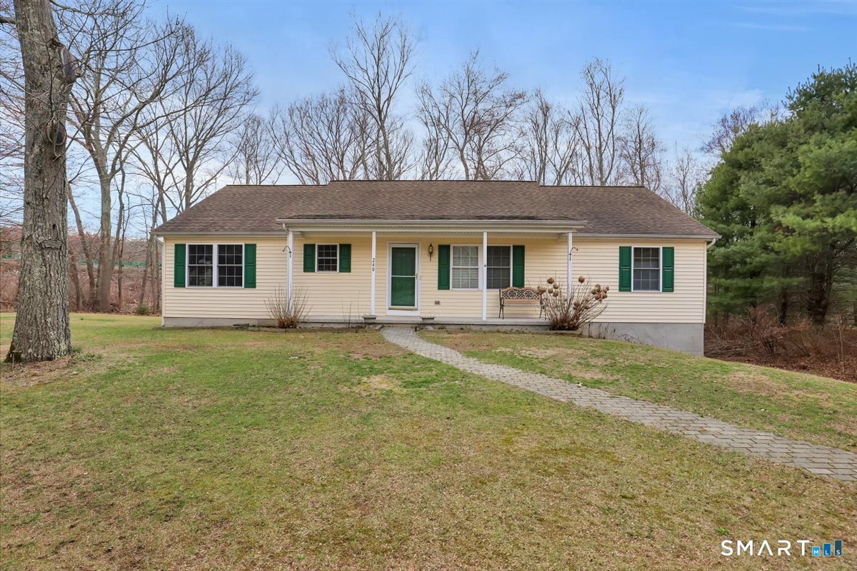 a view of a house with backyard and trees