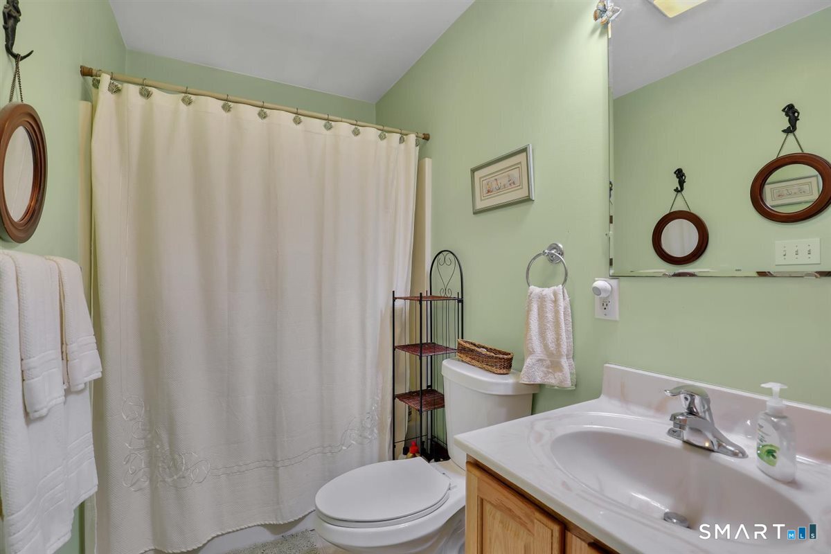 240 Elm Street Old Saybrook, CT 06475 - Photo 14 of 24 a bathroom with a sink vanity mirror and toilet