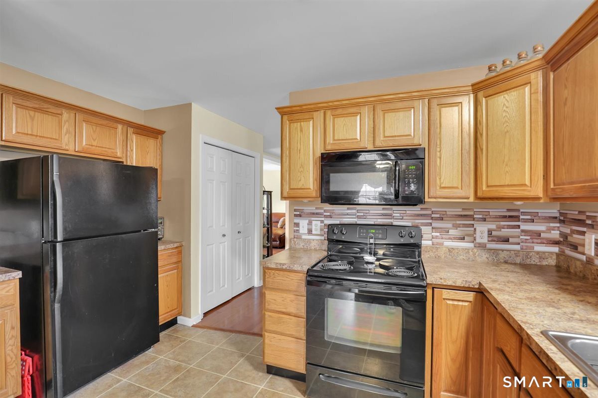 240 Elm Street Old Saybrook, CT 06475 - Photo 5 of 24 a kitchen with a refrigerator stove and microwave