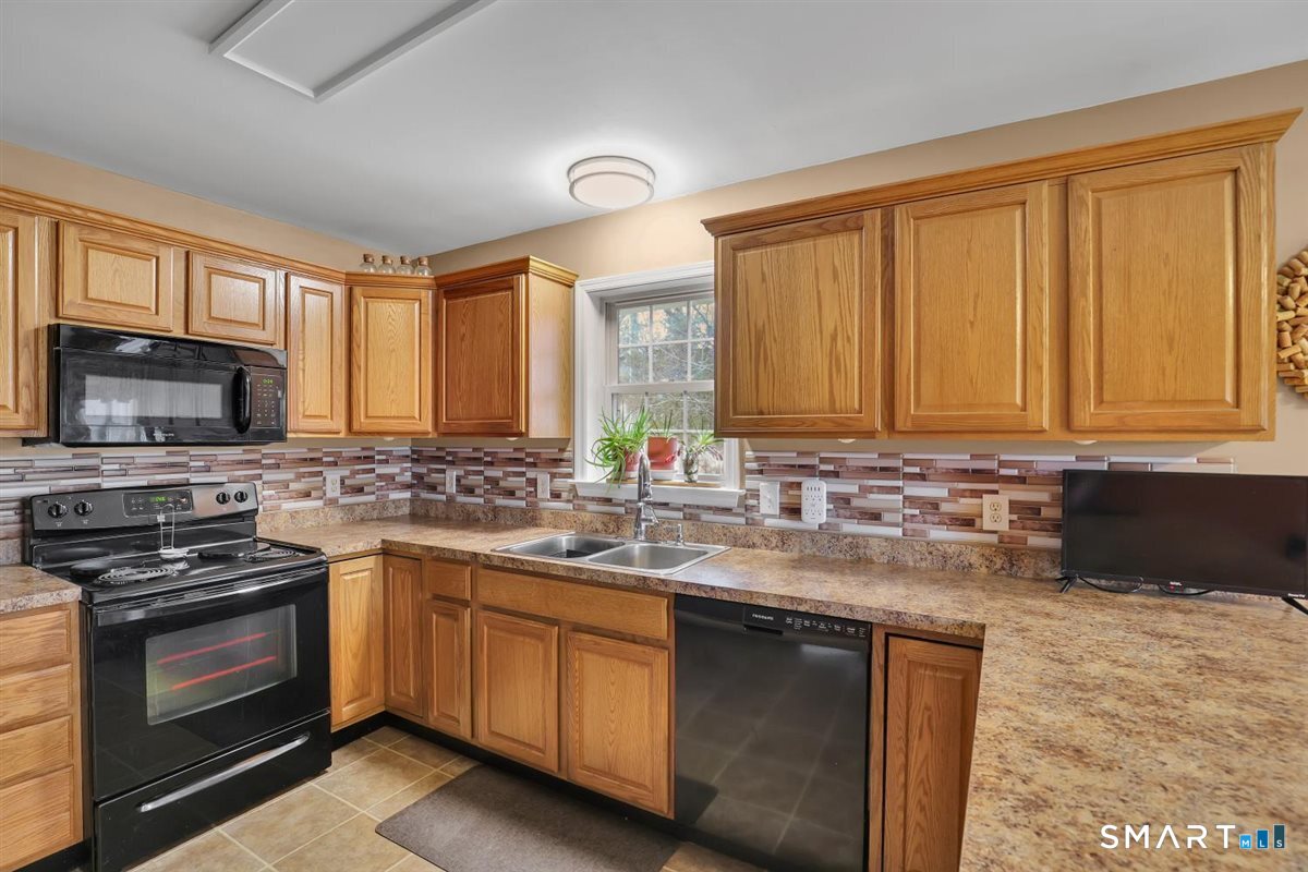240 Elm Street Old Saybrook, CT 06475 - Photo 6 of 24 a kitchen with stainless steel appliances granite countertop a stove a sink and a microwave