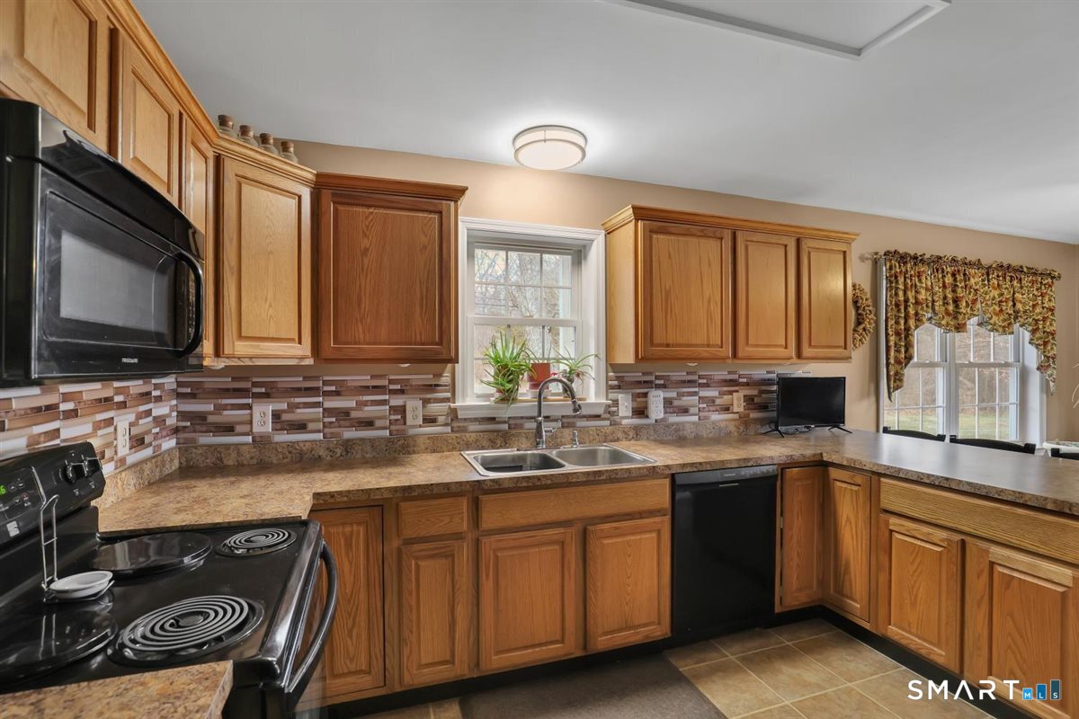 240 Elm Street Old Saybrook, CT 06475 - Photo 7 of 24 a kitchen with a sink stove and microwave