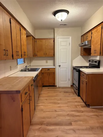 a kitchen with stainless steel appliances granite countertop a sink a stove and a refrigerator