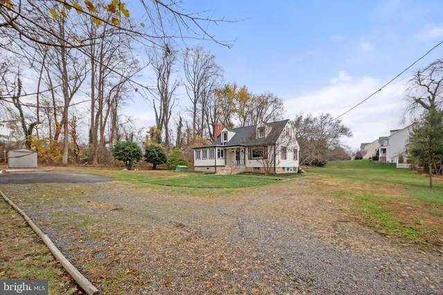 a view of a big house with a big yard and large trees