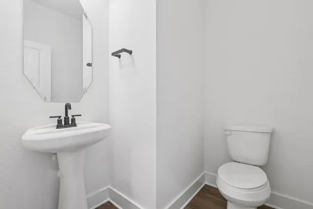 a bathroom with a toilet a sink and mirror