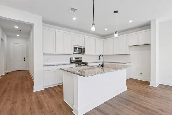 a kitchen with kitchen island a sink stainless steel appliances and cabinets