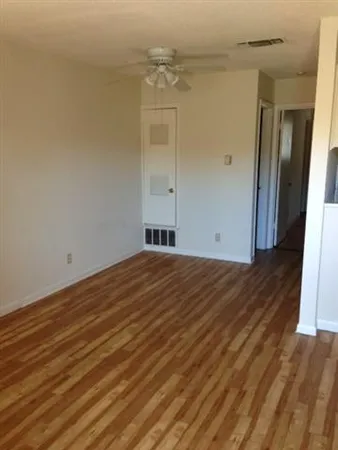 a view of empty room with wooden floor
