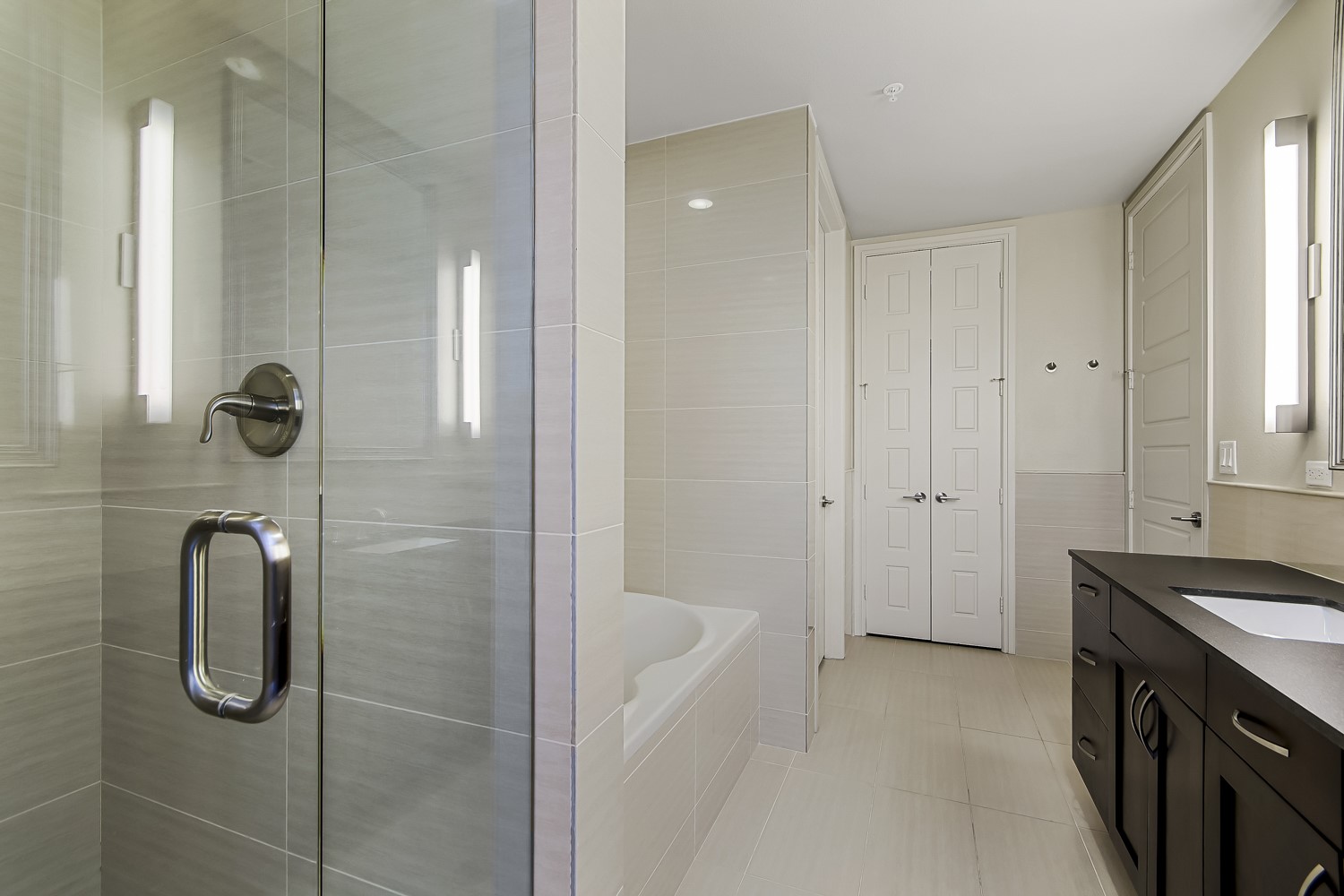 214 Barton Springs Road, Unit 1909 Austin, TX 78704 - Photo 4 of 34 Bathroom with vanity, a garden tub, tile walls, a stall shower, and light tile patterned floors