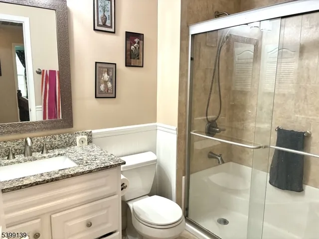a bathroom with a granite countertop sink toilet and shower