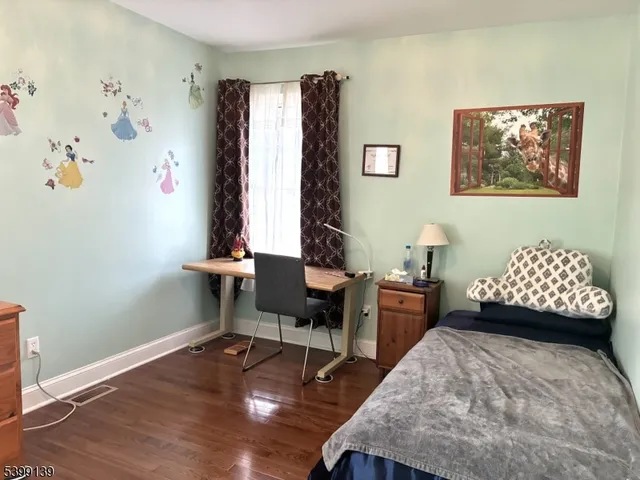 a bedroom with furniture and a wooden floor