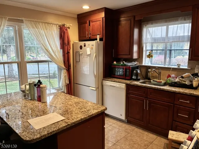 a kitchen with granite countertop a sink and a refrigerator