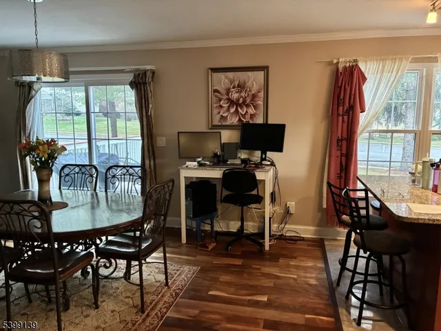 a dining room with furniture a chandelier and wooden floor