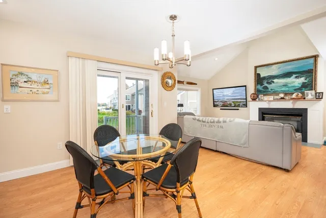 a view of a dining room with furniture a chandelier and wooden floor