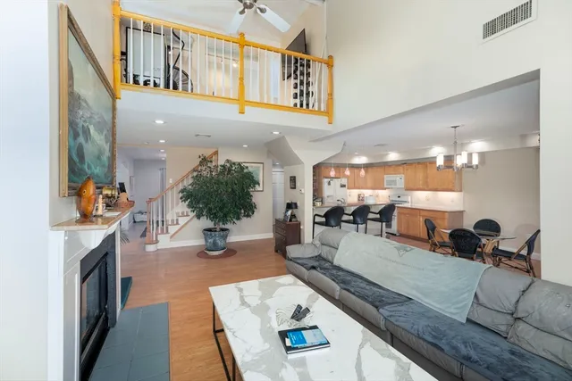a living room with furniture a fireplace and potted plant