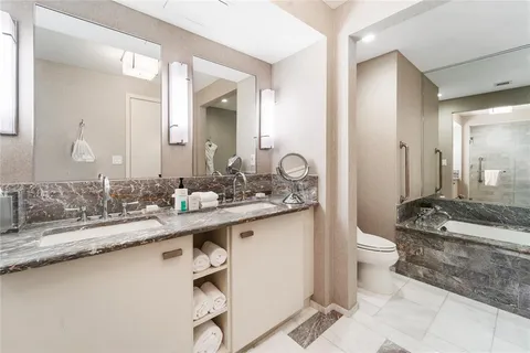 a bathroom with a granite countertop sink a toilet and a mirror
