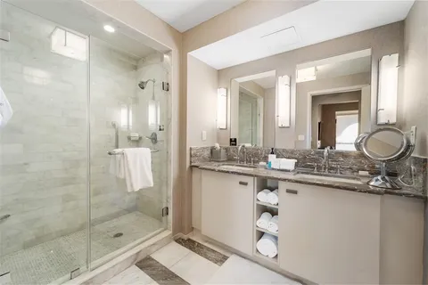 a bathroom with a granite countertop sink a mirror and a shower