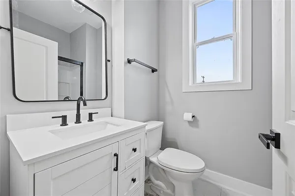 a bathroom with a toilet sink and mirror